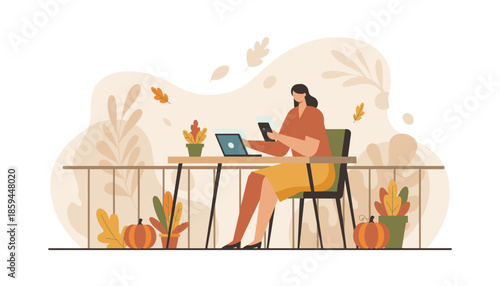 Woman uses laptop and phone for remote work on an autumnal terrace with pumpkins and falling leaves