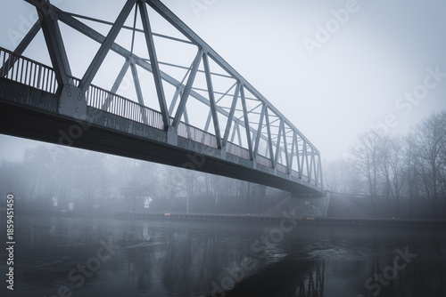 Metal bridge on the Mittellandkanal in Bramsche, Germany, in winter fog — moody canal landscape