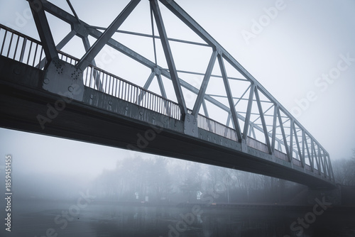 Metal bridge on the Mittellandkanal in Bramsche, Germany, in winter fog — moody canal landscape