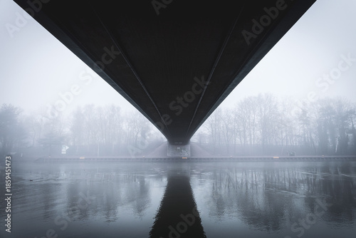 Metal bridge on the Mittellandkanal in Bramsche, Germany, in winter fog — moody canal landscape