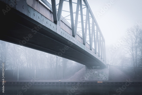 Metal bridge on the Mittellandkanal in Bramsche, Germany, in winter fog — moody canal landscape
