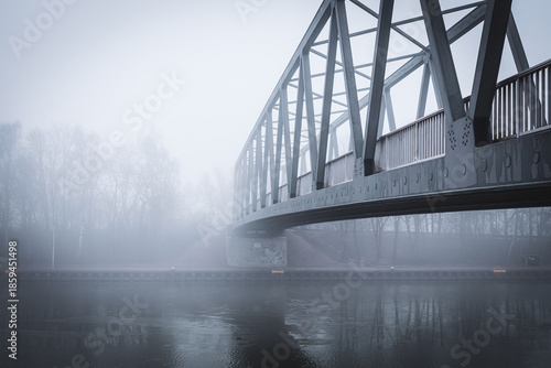 Metal bridge on the Mittellandkanal in Bramsche, Germany, in winter fog — moody canal landscape