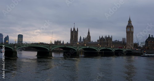 red buses, traffic and people on Westminster Bridge over the River Thames next to Big Ben and The Houses of Parliament, London, England