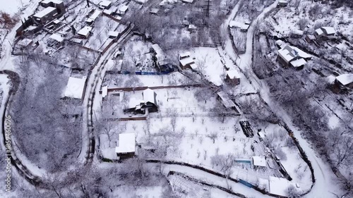 Drone flight over a rural Armenian village during a snowy winter