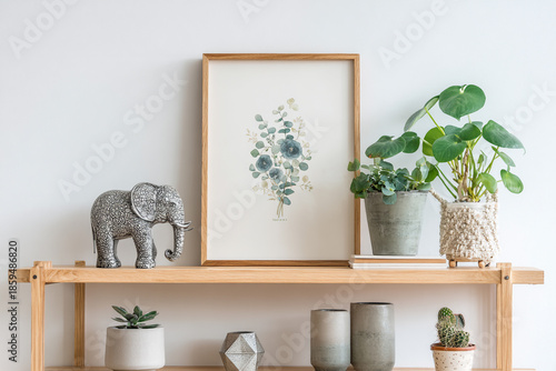 A minimalist wooden shelf displays an intricate elephant figurine a framed floral print and various potted plants including a monstera and a cactus