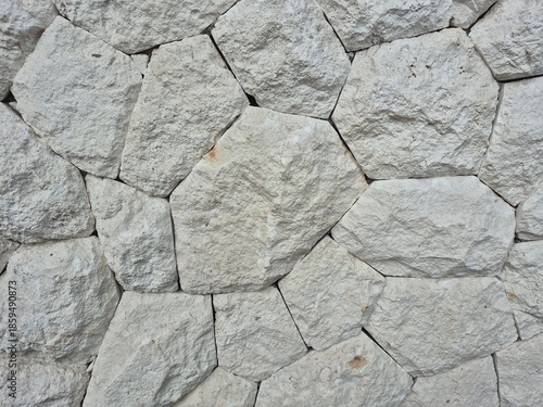 Natural stone wall texture with irregular rock pattern, rough surface background for architecture and outdoor design