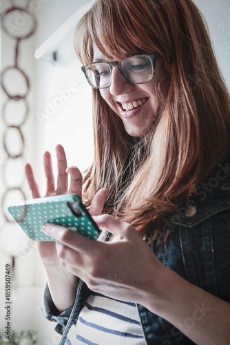 Woman Smiling While Holding and Tapping Phone