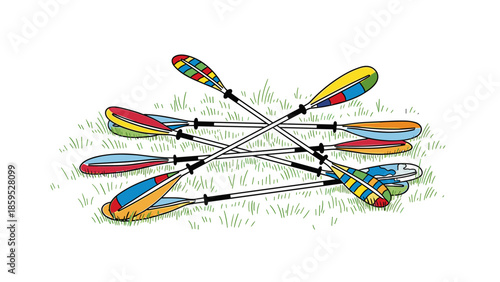 Colorful kayak paddles arranged on grass in a crossed pattern