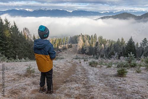 Φωτογραφία Child observing foggy mountain landscape in winter.
