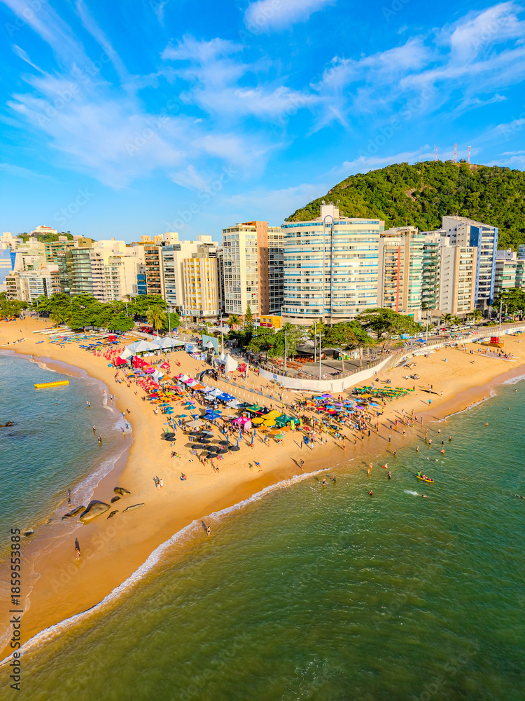 Obraz premium Imagem aérea da praia da costa em Vila Velha com o morro do Moreno ao fundo durante um evento esportivo de natação. Esporte aquático no litoral do Espírito Santo.