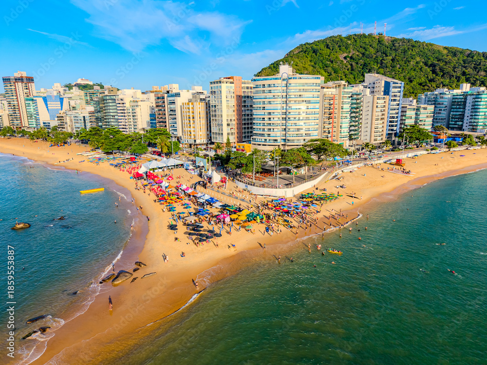 Obraz premium Imagem aérea da praia da costa em Vila Velha com o morro do Moreno ao fundo durante um evento esportivo de natação. Esporte aquático no litoral do Espírito Santo.