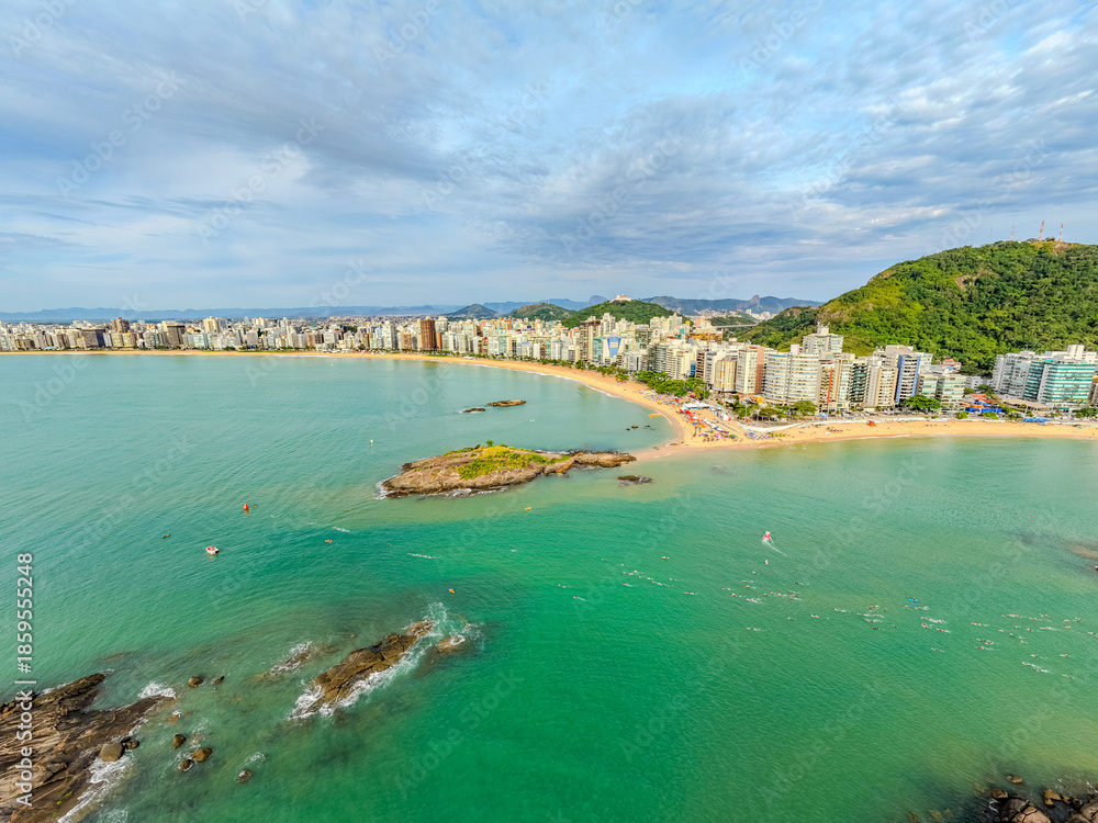 Fototapeta premium Imagem aérea da praia da costa em Vila Velha com o morro do Moreno ao fundo durante um evento esportivo de natação. Esporte aquático no litoral do Espírito Santo.