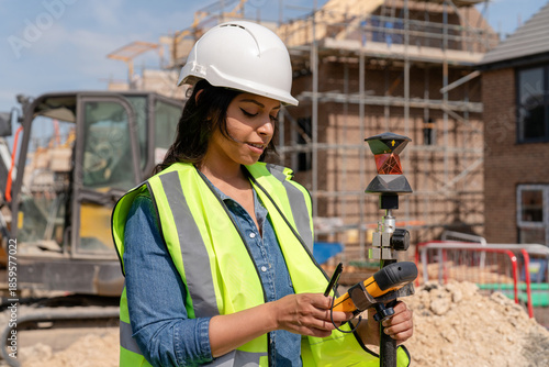 Φωτογραφία Confident Female Building Surveyor using surveying instrument to conducting meas