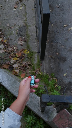 Vertical Video of Hand Pressing Remote as Metal Garage Door Opens