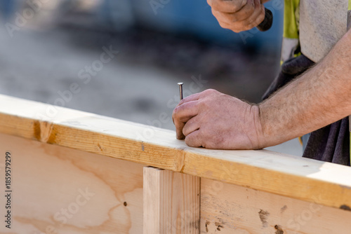 Canvas Print Close-up of hands of builder joiner using plywood and timber to asseble shutter