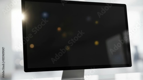 Modern desktop monitor with blank black screen on sleek office desk in bright workplace interior with soft bokeh light reflections, 4k video