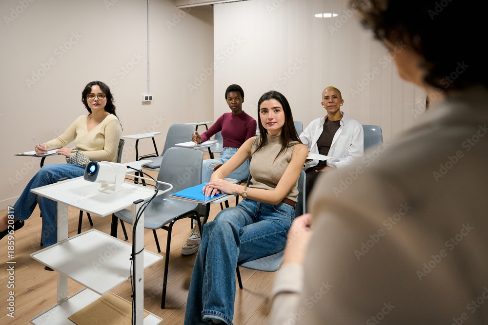 Fototapeta premium Diverse women students attending university lecture in classroom