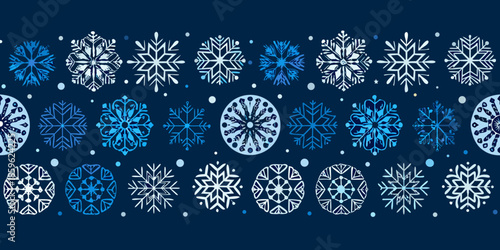 Seamless pattern of delicate snowflakes in shades of blue and white
