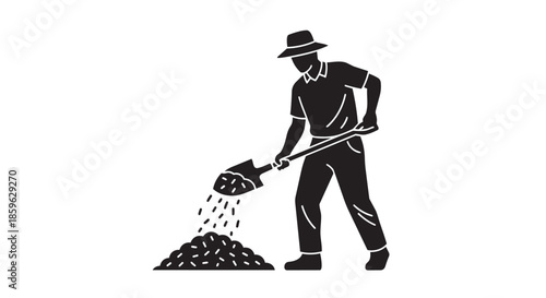 Man in a hat vigorously shoveling soil or aggregate onto a heap, depicting manual labor