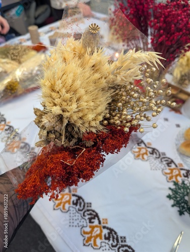 Natural dried flowers bouquet with wheat, lagurus and red plants, rustic floral decor background.