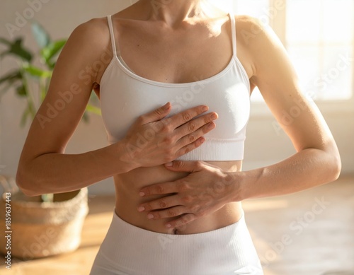 Woman practicing mindful breathing exercise with hands on chest and abdomen
