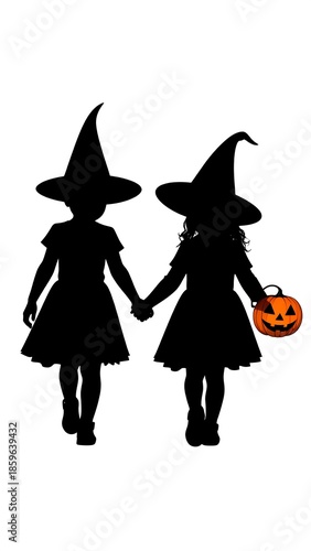Two children in Halloween witch costumes, walking hand-in-hand