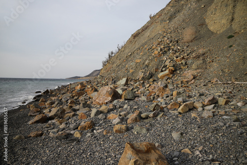 A powerful collapse of rocks in the sea. Dramatic view to illustrate the power of nature, danger, environmental change, news.