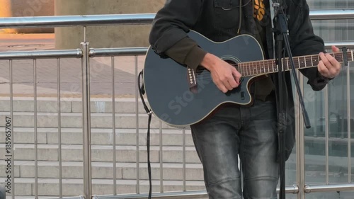 Wallpaper Mural A street musician plays the guitar. Faceless. People, culture and environment. Live music. City life. The frame shows a musical instrument, hands, strings and feet. Atmospheric B-roll Torontodigital.ca