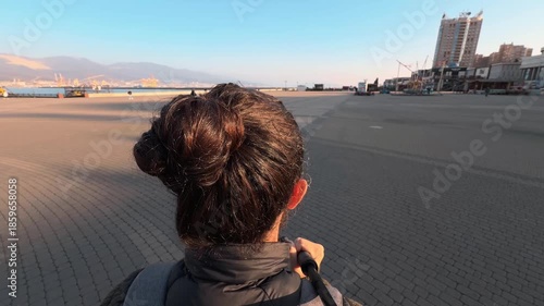 Wallpaper Mural A walk along the paved embankment of Novorossiysk. Rear view. Bodycam footage. Back of a man's head with long hair. Golden hour. Wide angle. Atmospheric B-roll Torontodigital.ca