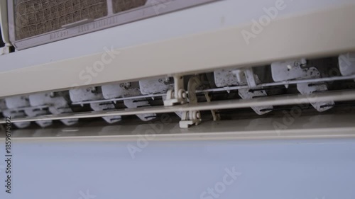 Close-up view of a dirty air conditioner indoor unit with dust and mold on the air vents and louvers. Concept of poor air quality, maintenance, hygiene, cleaning, and home appliance service issues.