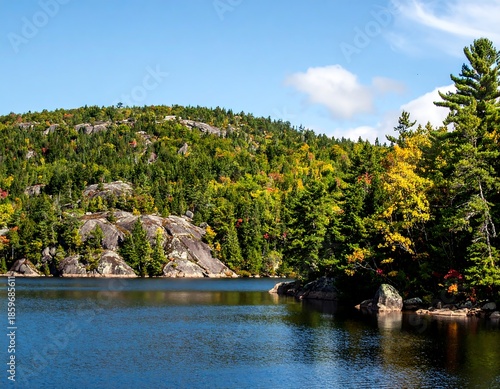 Autumn landscape of a lake with rocky shore and colorful trees