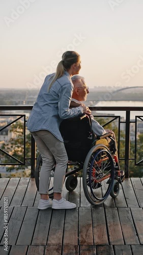 Woman shows city architecture to aged father in wheelchair