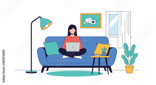 Relaxed woman works on her laptop while sitting cross-legged on a comfortable blue sofa in a cozy home office environment.
