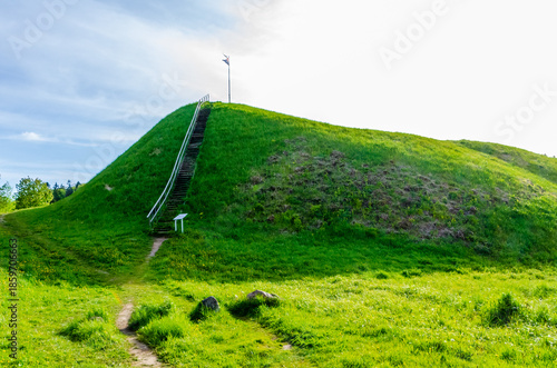 Foto Historic green hill with wooden stairs leading upward under bright summer sky