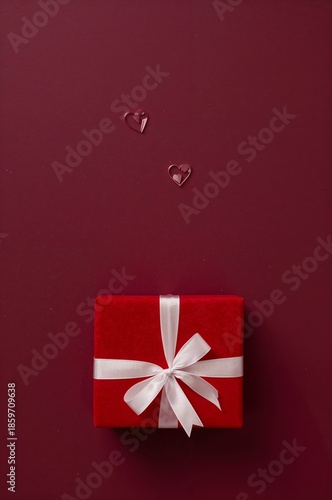 Red Gift Box With White Ribbon and Small Hearts on Dark Background