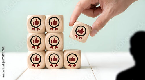 Hand placing thumbs up approval cube among stacked rating blocks