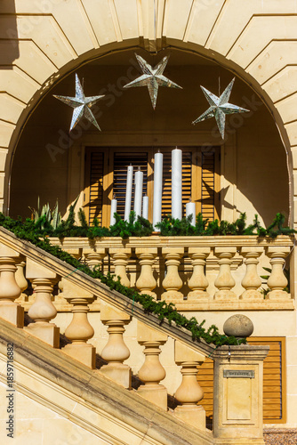 Elegant Balcony Archway With Candles, Silver Stars, And Greenery On Stately Staircase