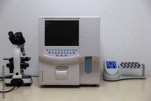 On the table is a hematology analyzer, microscope, centrifuge. Workplace of a medical laboratory assistant.