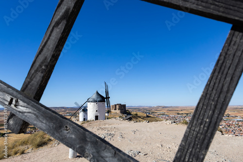 Consuegra windmills and castle under bright blue sky