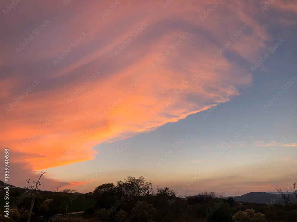 Obraz premium Dramatic sunset cloudscape with orange and pink sky over natural horizon