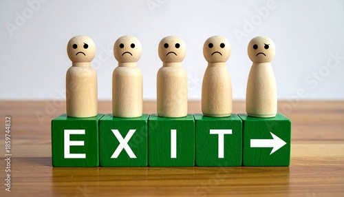 Row of Sad Wooden Peg People Standing on Green Blocks Spelling EXIT with Directional Arrow on a Wooden Surface