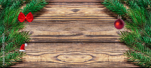 Christmas wooden background with a red Christmas ball and fir branches. Top view, flat lay, space for text.