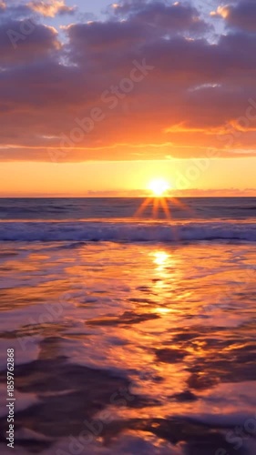 Ocean sunset with vibrant colors of orange and purple sunlight reflecting on the water at dusk