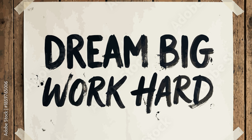Inspirational handcrafted poster reads dream big work hard, attached to rustic wooden wall with tape, offering motivation and encouragement, perfect for office or home decor