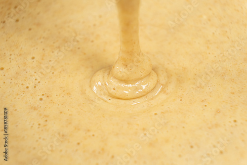 Texture of smooth creamy batter flowing down.
