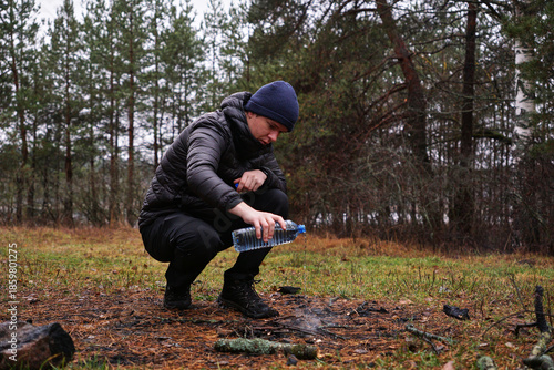 Foto A man puts out a fire with a bottle of water