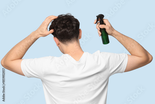 Handsome young man spraying...