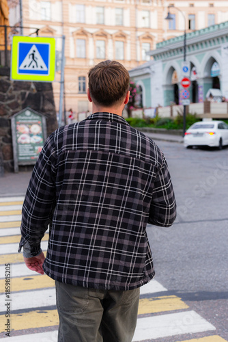 Male Individual Crossing Busy City Street, Caucasian Man Strides Through City Crosswalk With Purpose