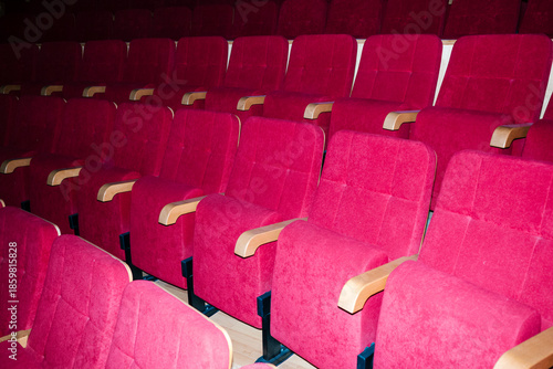 Empty rows of red velvet theater seats