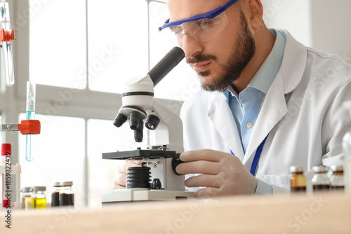 Male scientist looking thro...